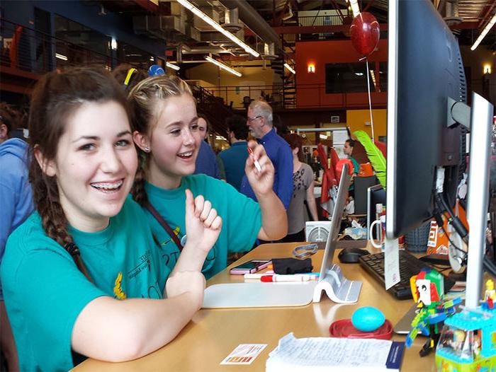 Two STEM students sitting at a table working on a computer